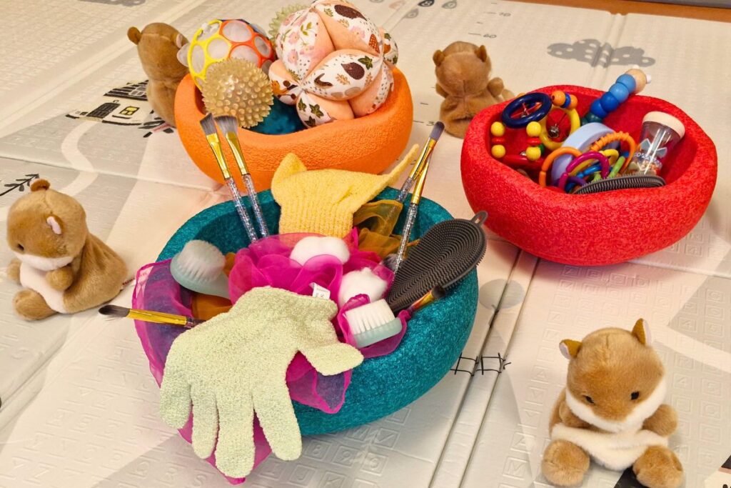 Vorbereitete Spiel und Sinnesmaterialien aus einem bindungsorientierten Babykurs in Dresden zum gemeinsamen Entdecken, Spielen und Ausprobieren für Babys und Kleinkinder